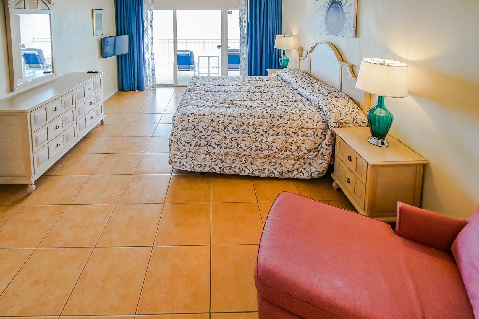 A spacious master bedroom with a balcony at VRI's Discovery Beach Resort in Cocoa Beach, Florida.